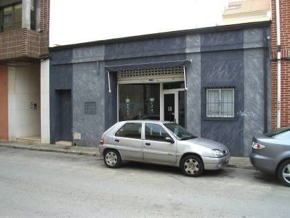 coche gris aparcado frente a portal de vivienda